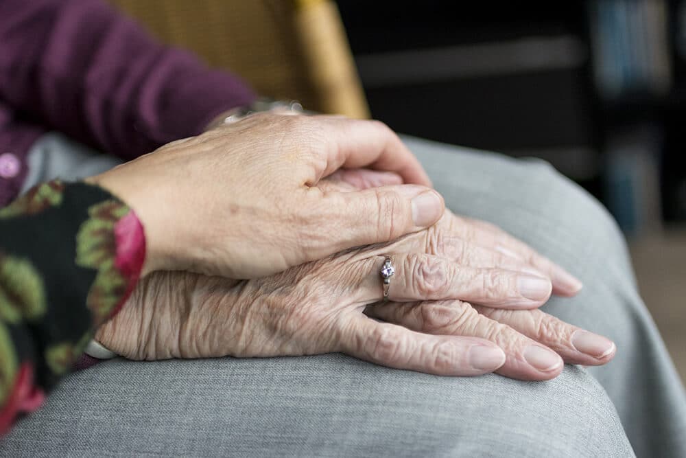 Person holding senior's hand