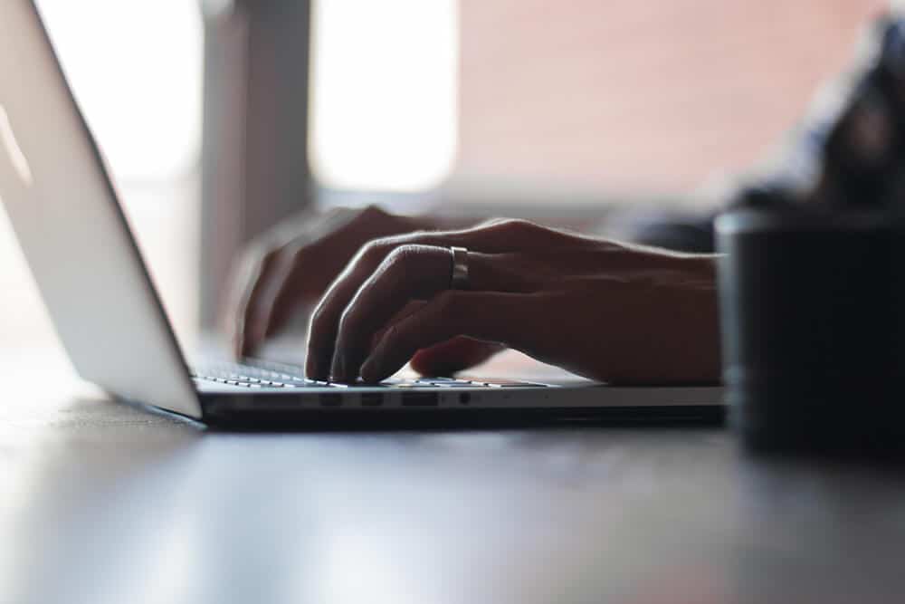 Closeup of hands typing on laptop