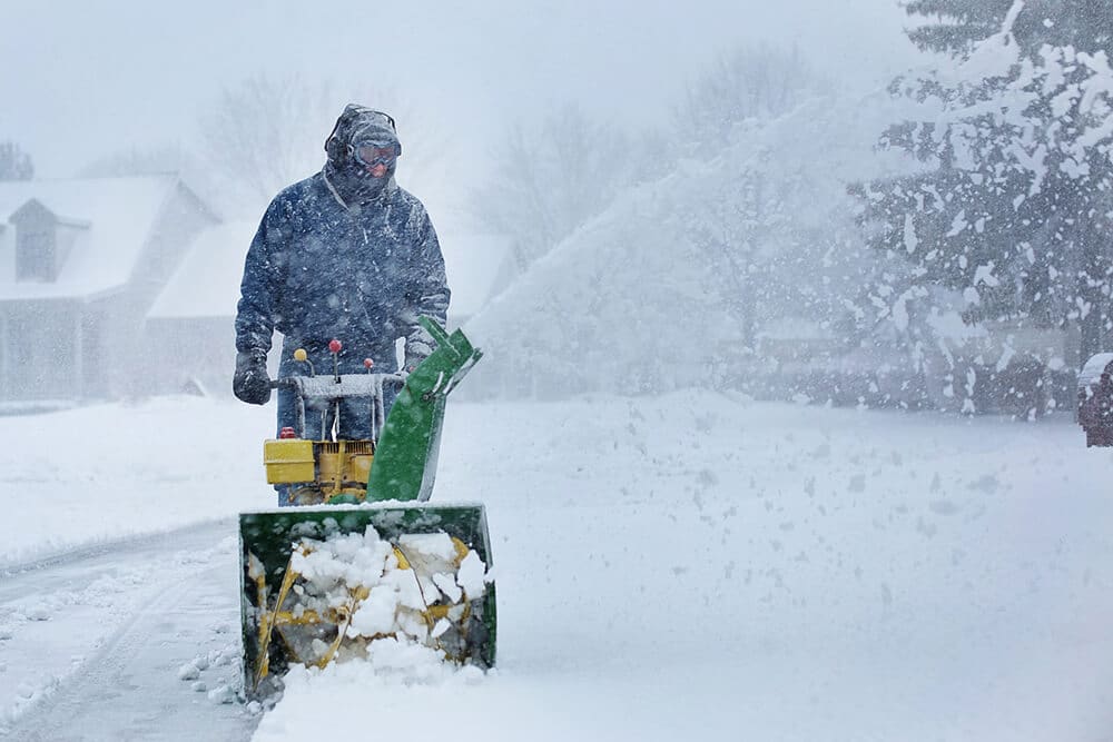 Man pushing snow plow toward camera